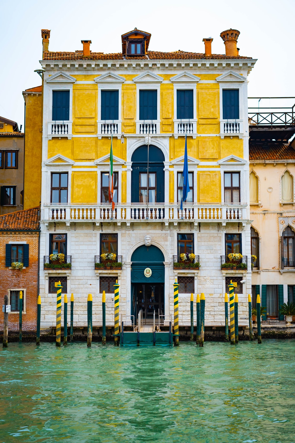 1234x1851, 615 Kb / Венеция, Италия, дом, канал, вода, фасад, флаги, столбы, сваи